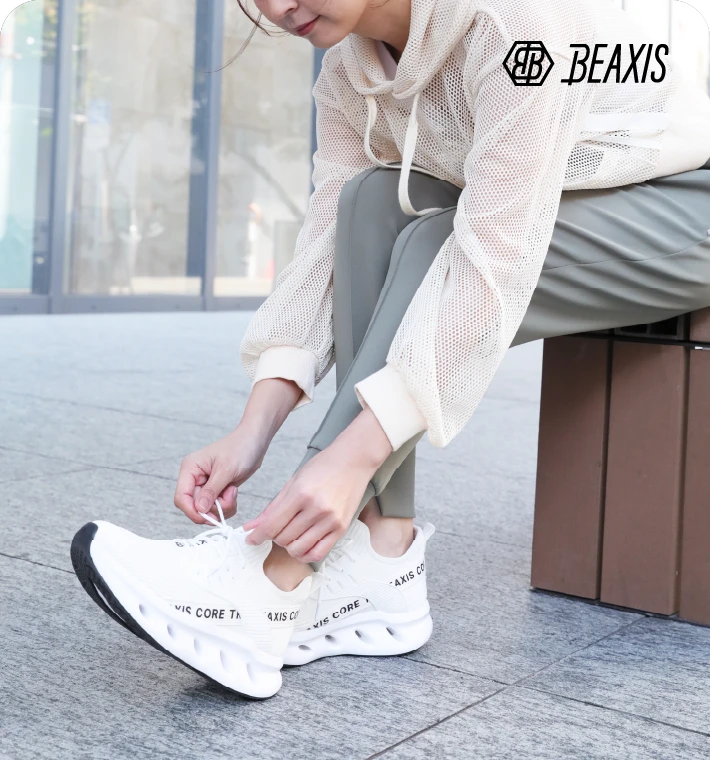 シェイプコアスニーカーを履いて座っている女性モデルの手元